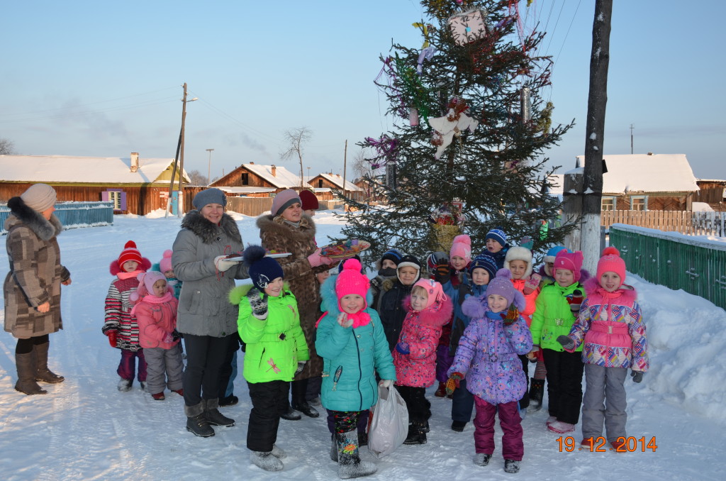 воспитатели детского сада с детьми украшают  новогоднюю елку с.Мирный